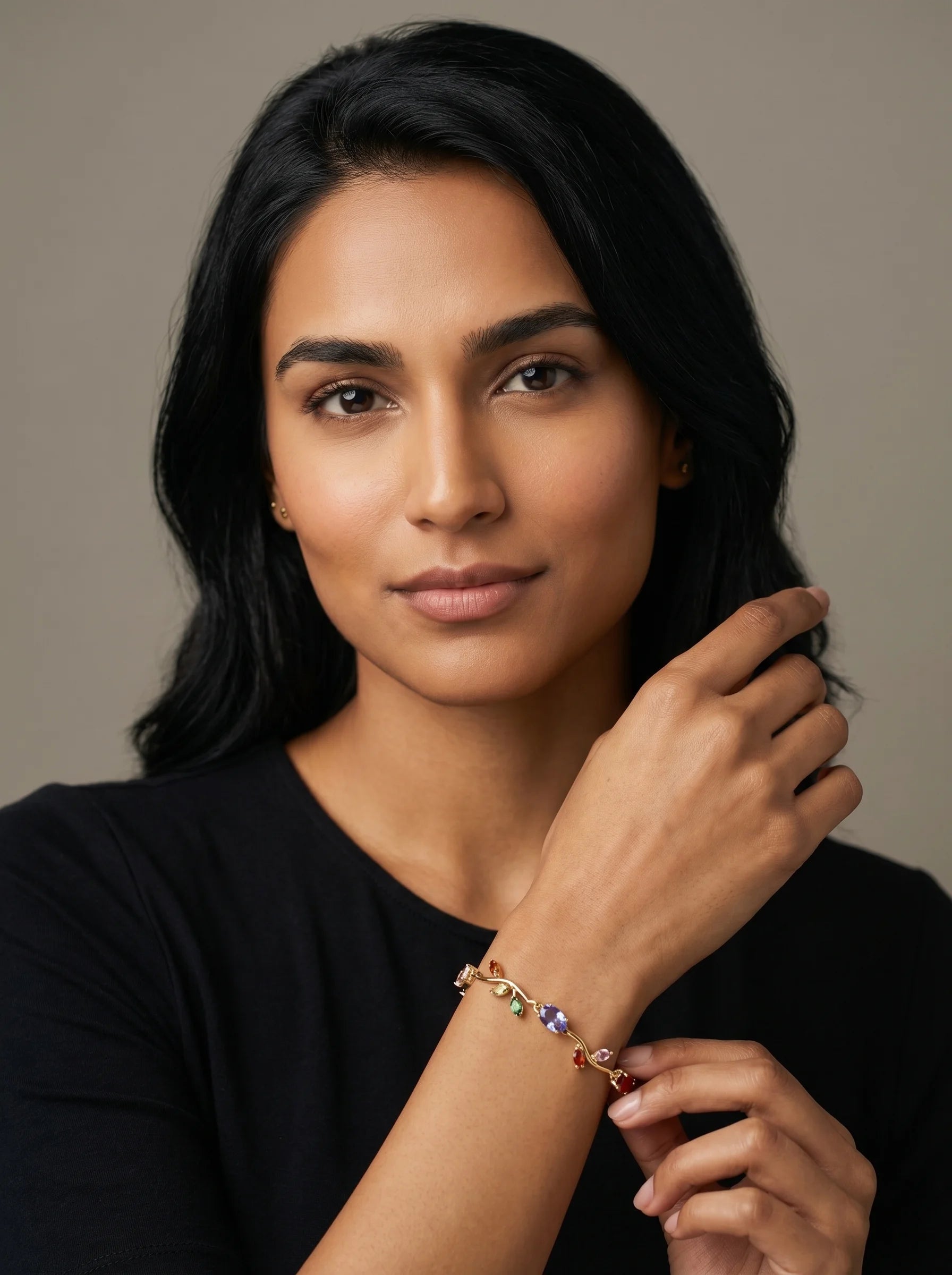 Model wearing Aurum & Isle Flora vine bracelet with coloured gemstone detailing, styled with black top.