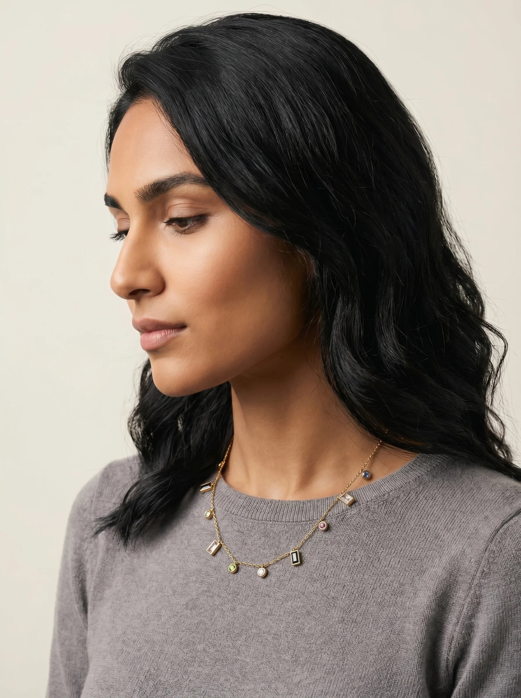 Aurum & Isle Mosaic charm gold necklace styled with grey cashmere — anti-tarnish everyday jewellery.