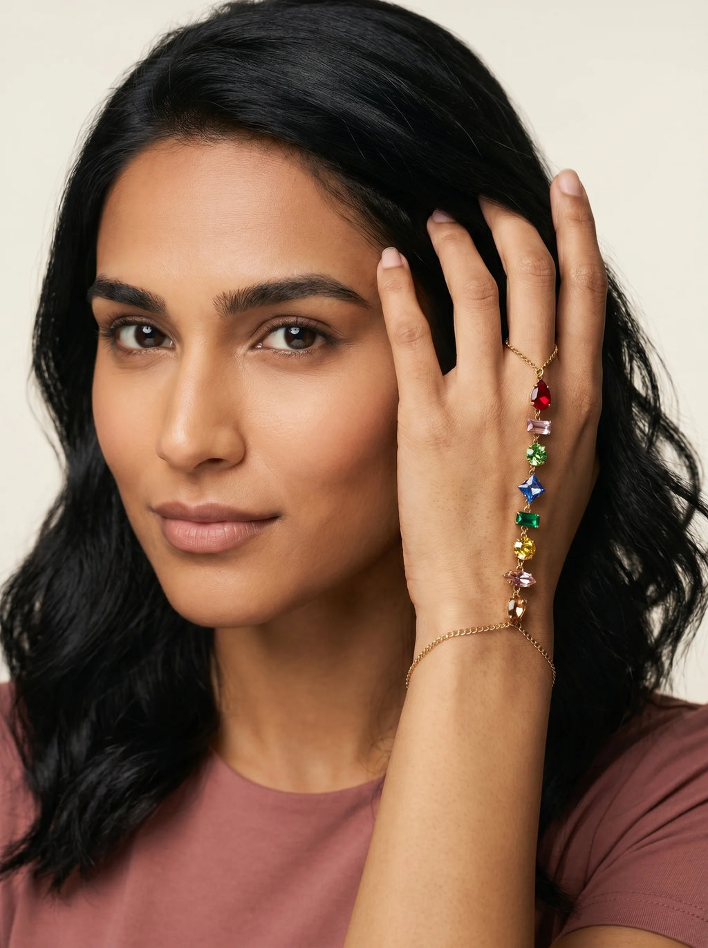 Aurum & Isle Prism gold hand harness worn on hand — ring, chain and bracelet structure with coloured stones.