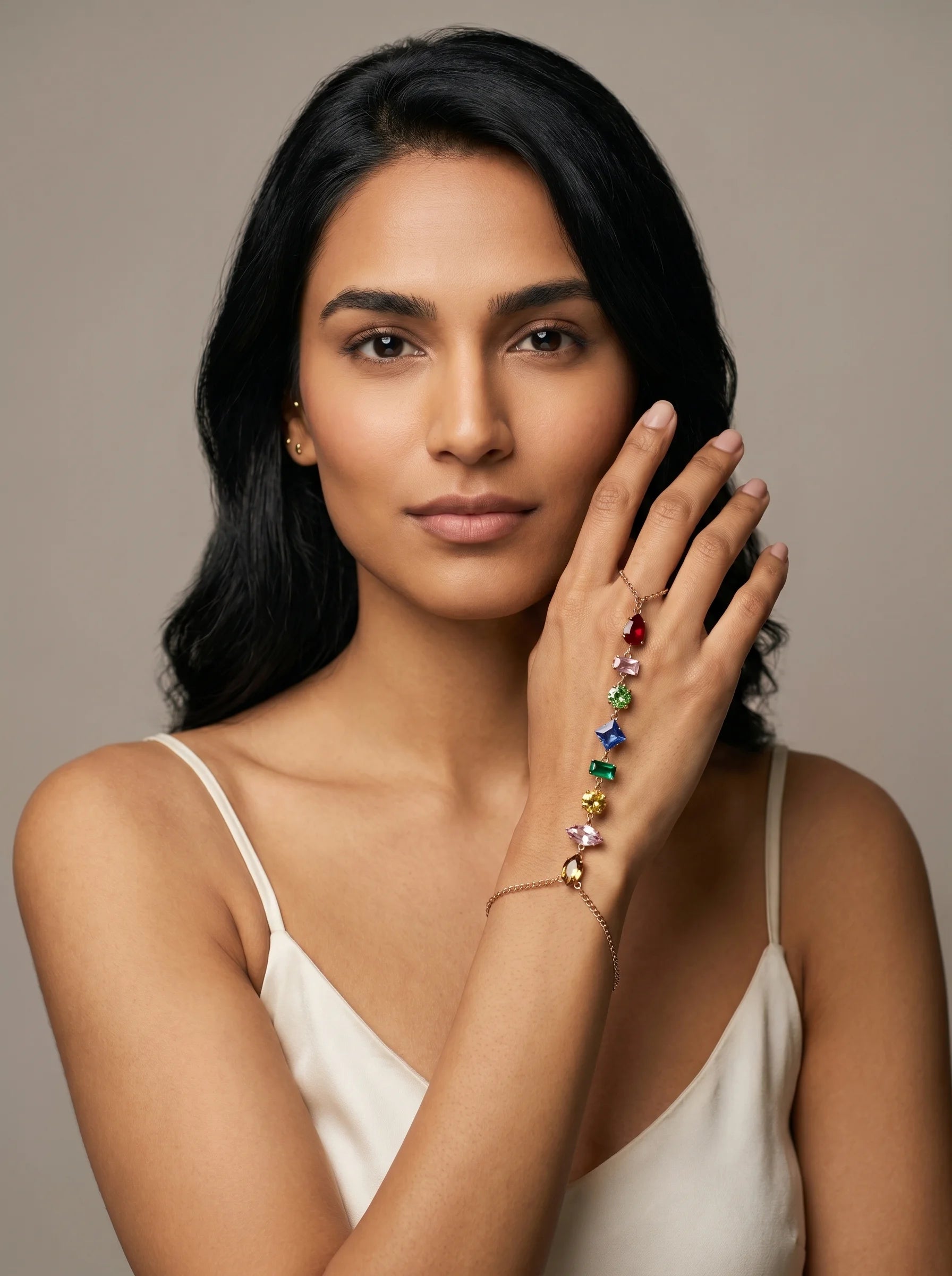 Model wearing Aurum & Isle Prism gold hand harness with multicoloured gemstones, paired with cream slip.
