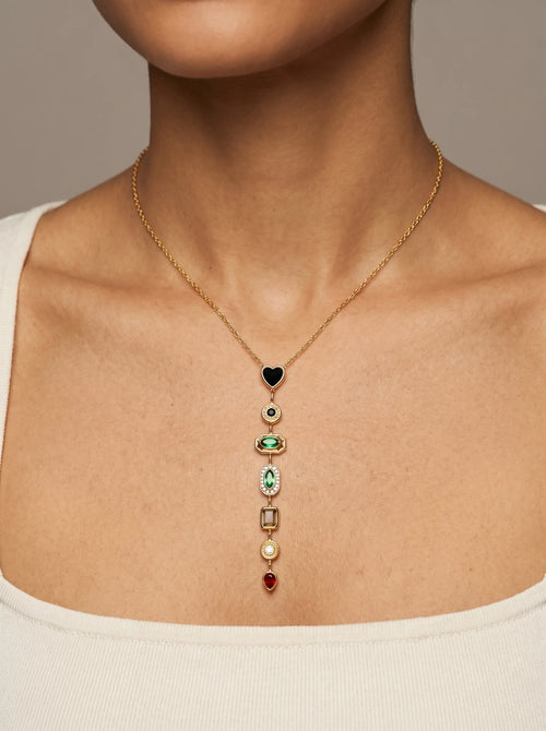 Close-up of Aurum & Isle Éclat Y-drop necklace — gold lariat with heart, emerald, ruby and pearl stones.