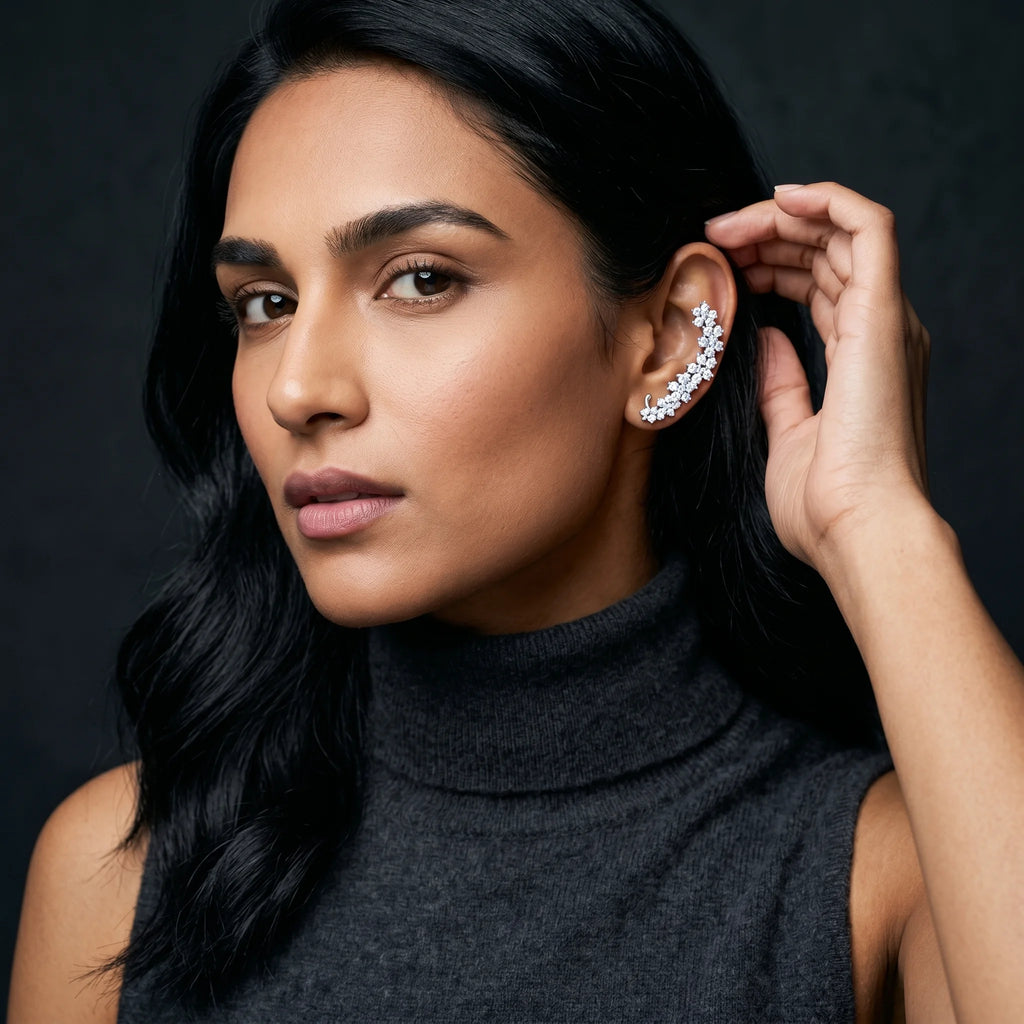 Indu silver floret climber ear cuff worn on model with charcoal turtleneck — close-up with hand near ear