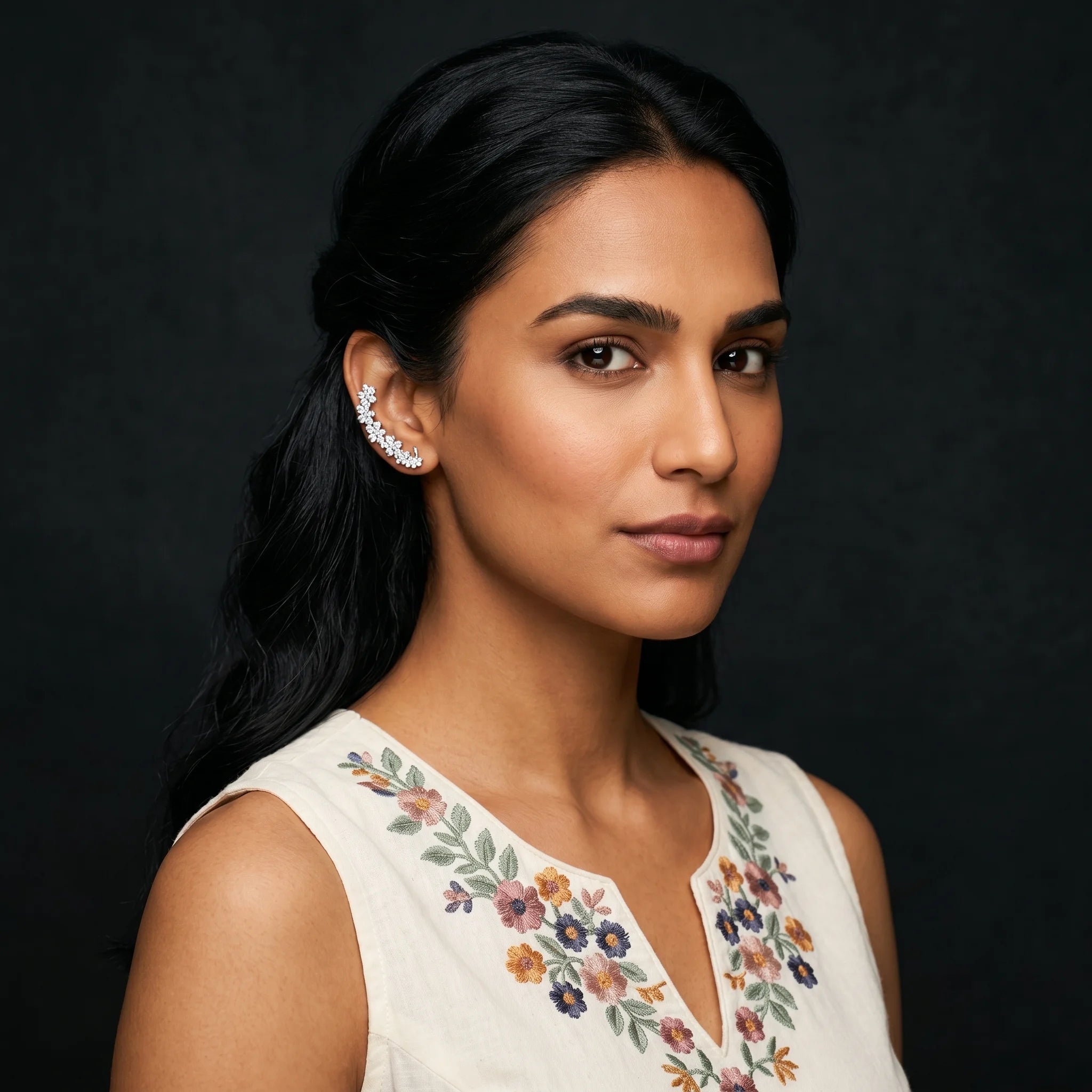 Indu silver climber cuff worn with white floral-embroidered top — soft editorial portrait