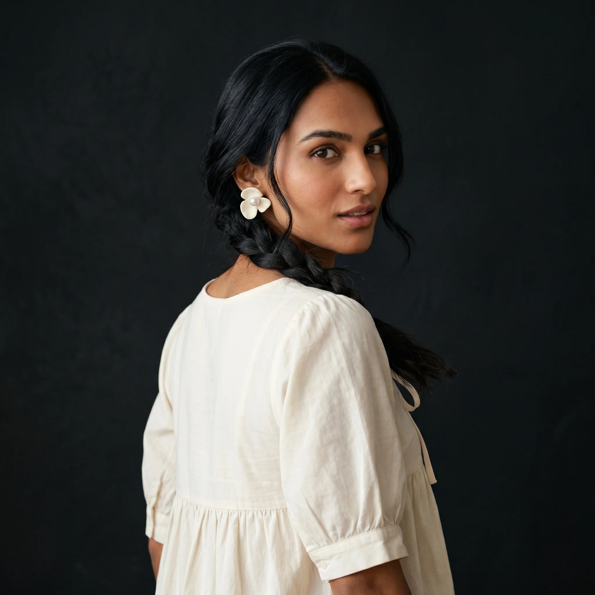 Kalika matte cream flower clip-on earring three-quarter turn with cream tie-front blouse