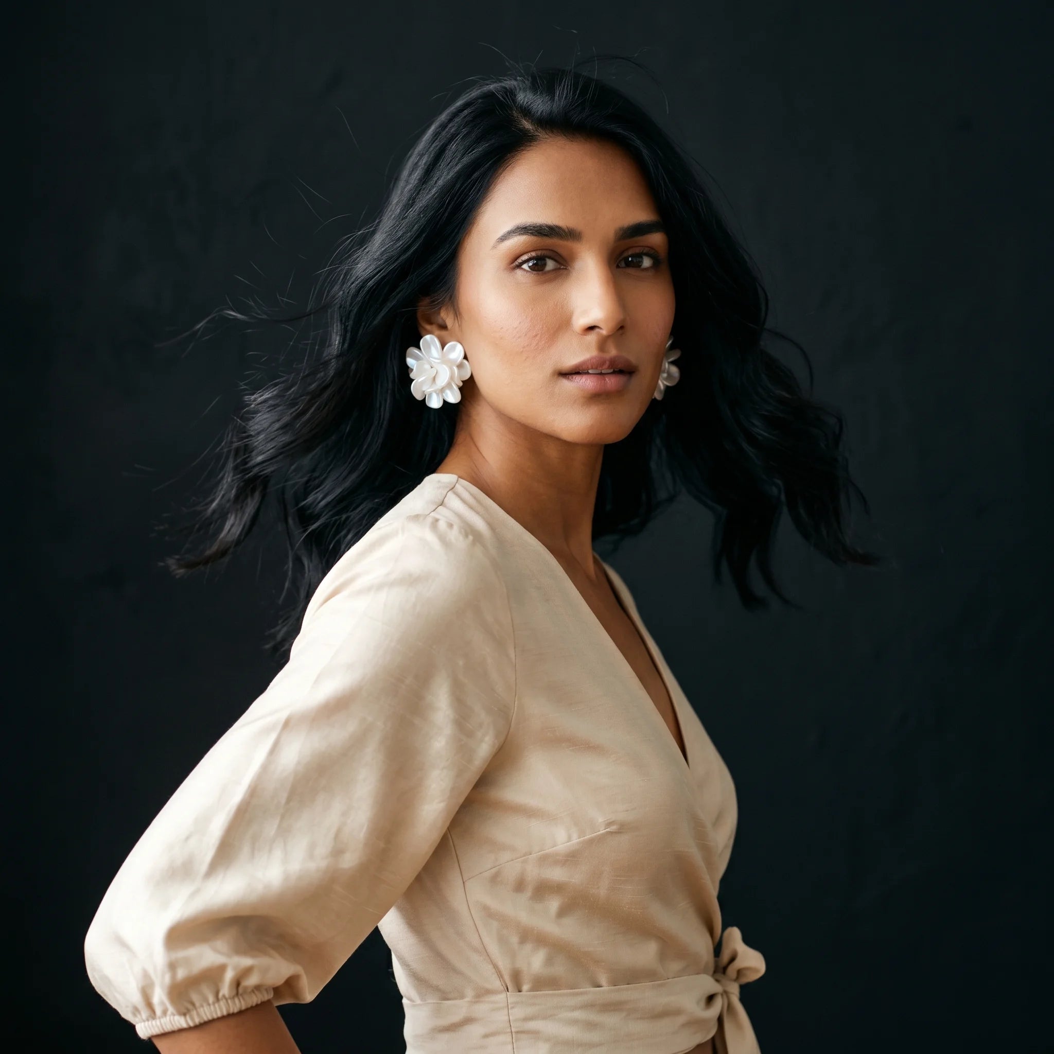 Malati pearlescent jasmine cluster studs worn with cream linen wrap — side three-quarter turn