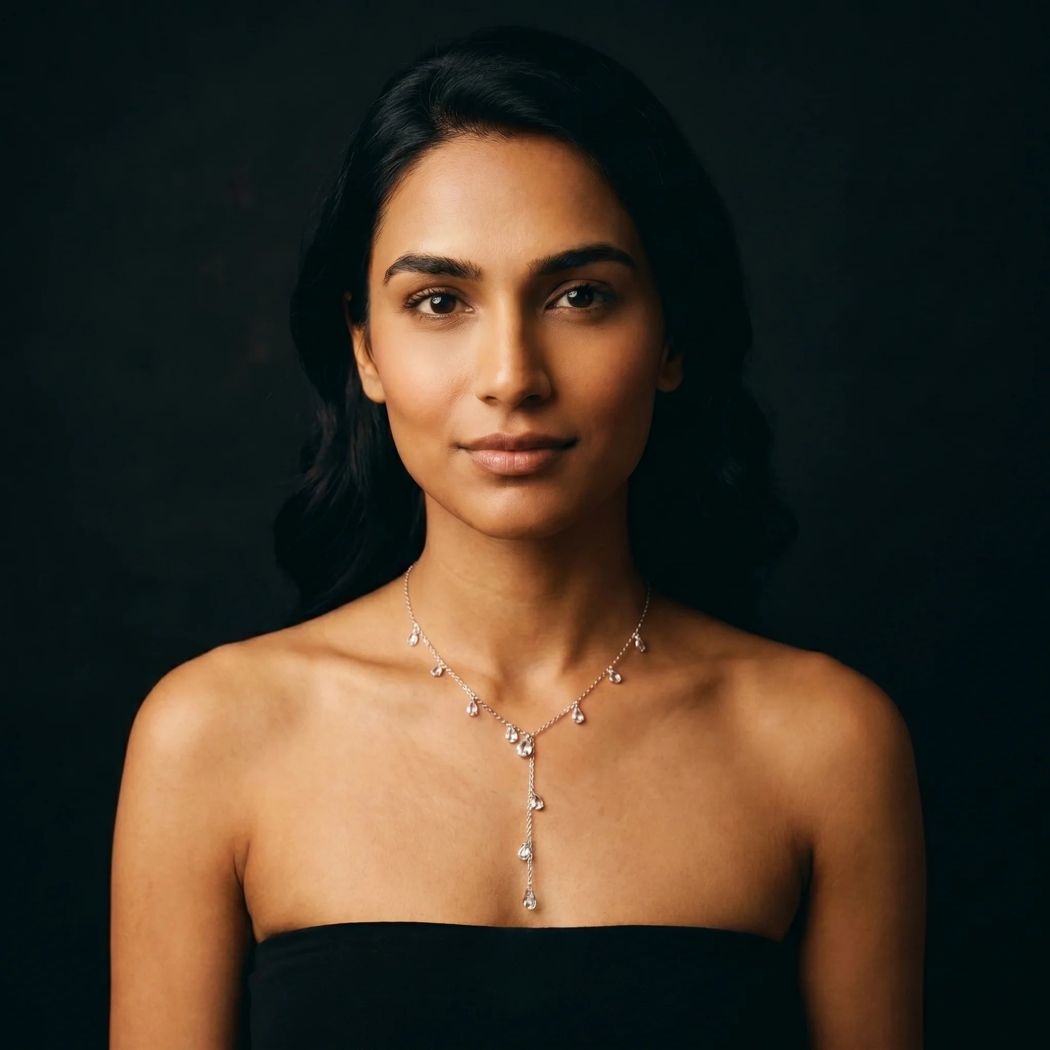 Nira silver teardrop Y-necklace worn front-facing with black strapless top