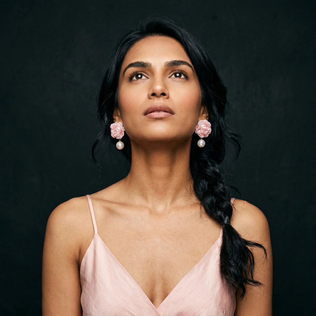 Roza rose-and-pearl drop earrings worn with blush pink slip dress and side braid — eyes closed