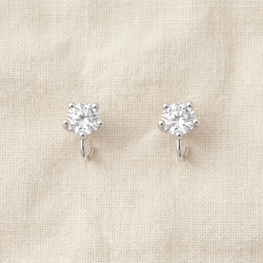 Tara silver-prong cubic zirconia solitaire stud earrings on cream linen — Aurum & Isle