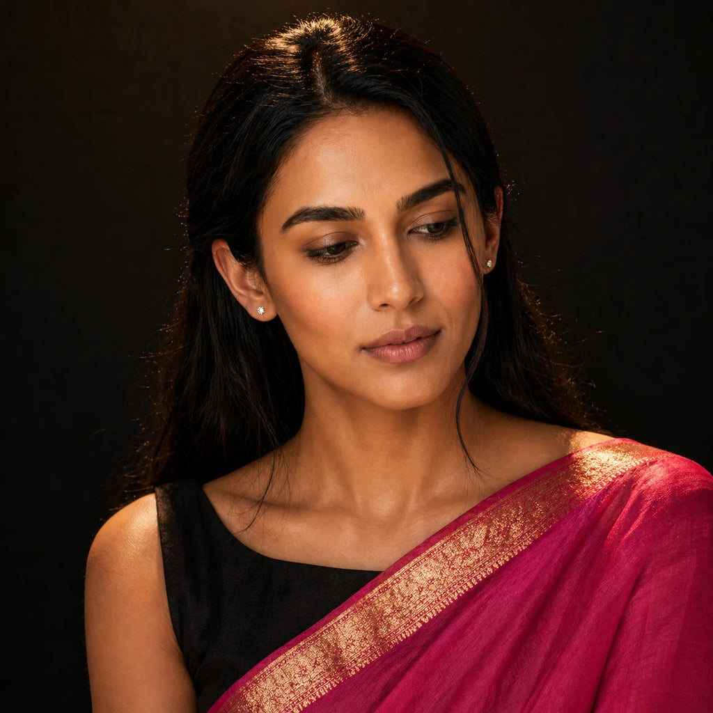 Tara silver CZ stud earrings worn with magenta-pink silk saree and gold border — eyes-down portrait